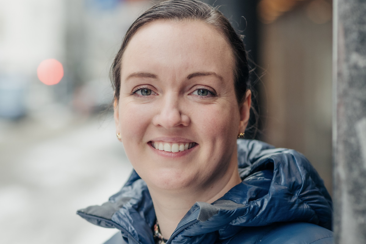 Nærbilde av kvinne som smiler. Hun er utendørs og har boblejakke på.